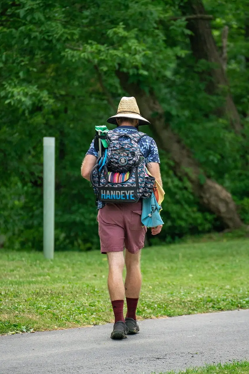 Man walking in disc golf apparel and equipment